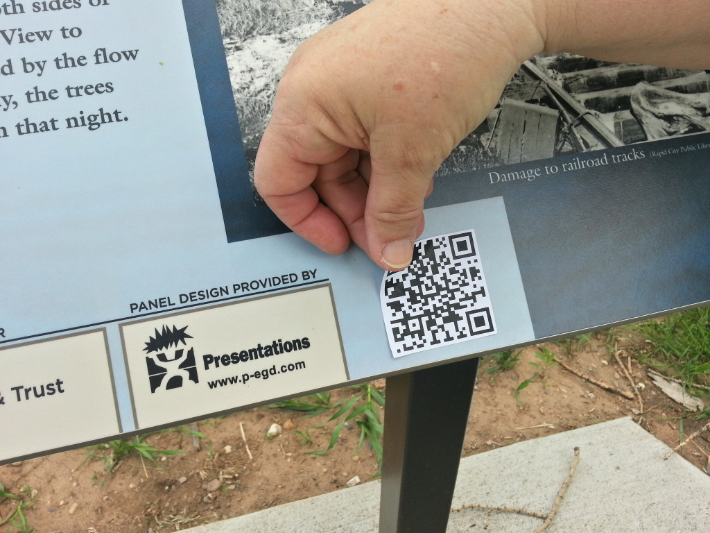 QR code affixed to interpretive sign on bike path.